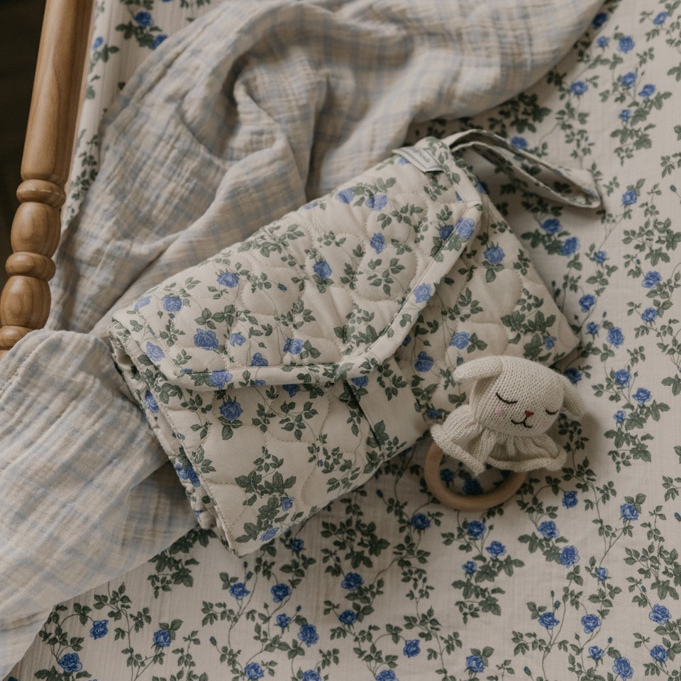 portable changing mat in flower print laying on a changing mat