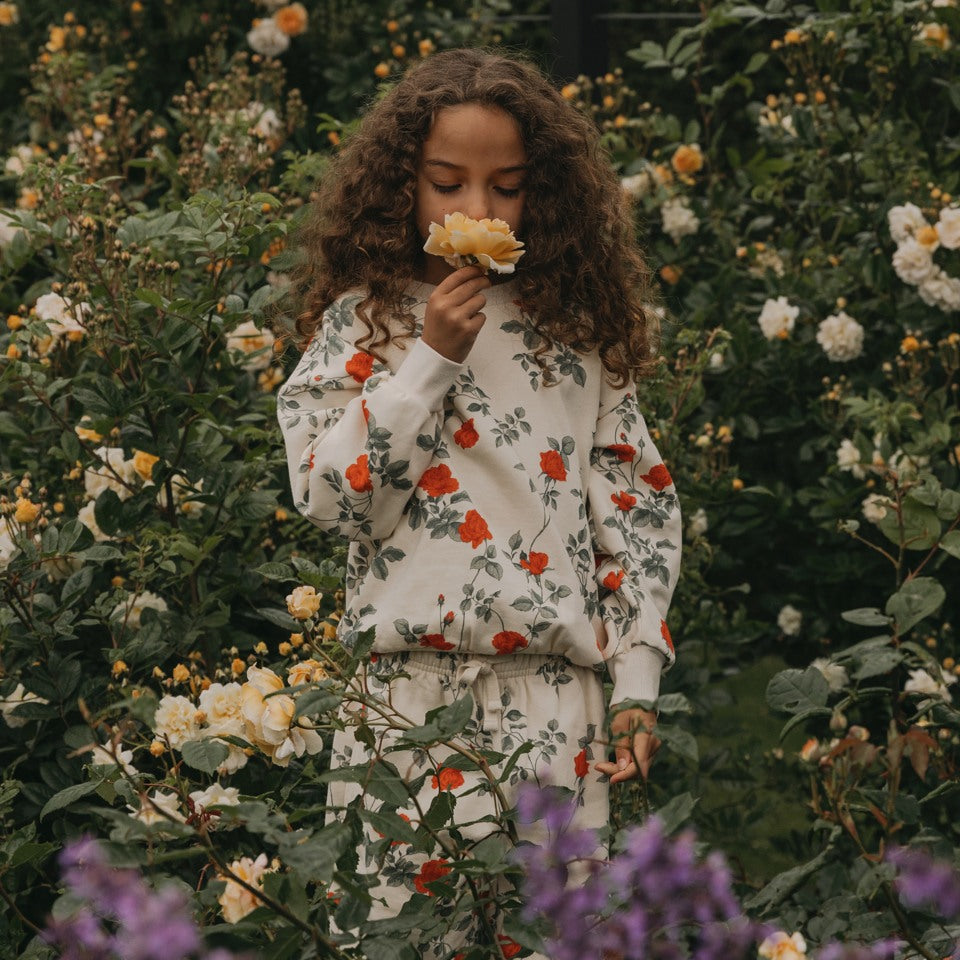 Girl smelling the flower in a flower field 